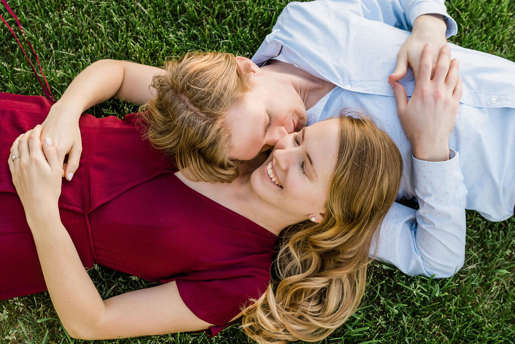 Engaged couple laying in the grass