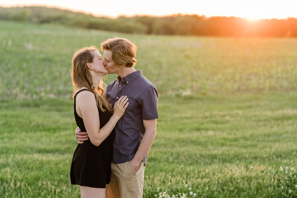 Engaged couple kissing at sunset