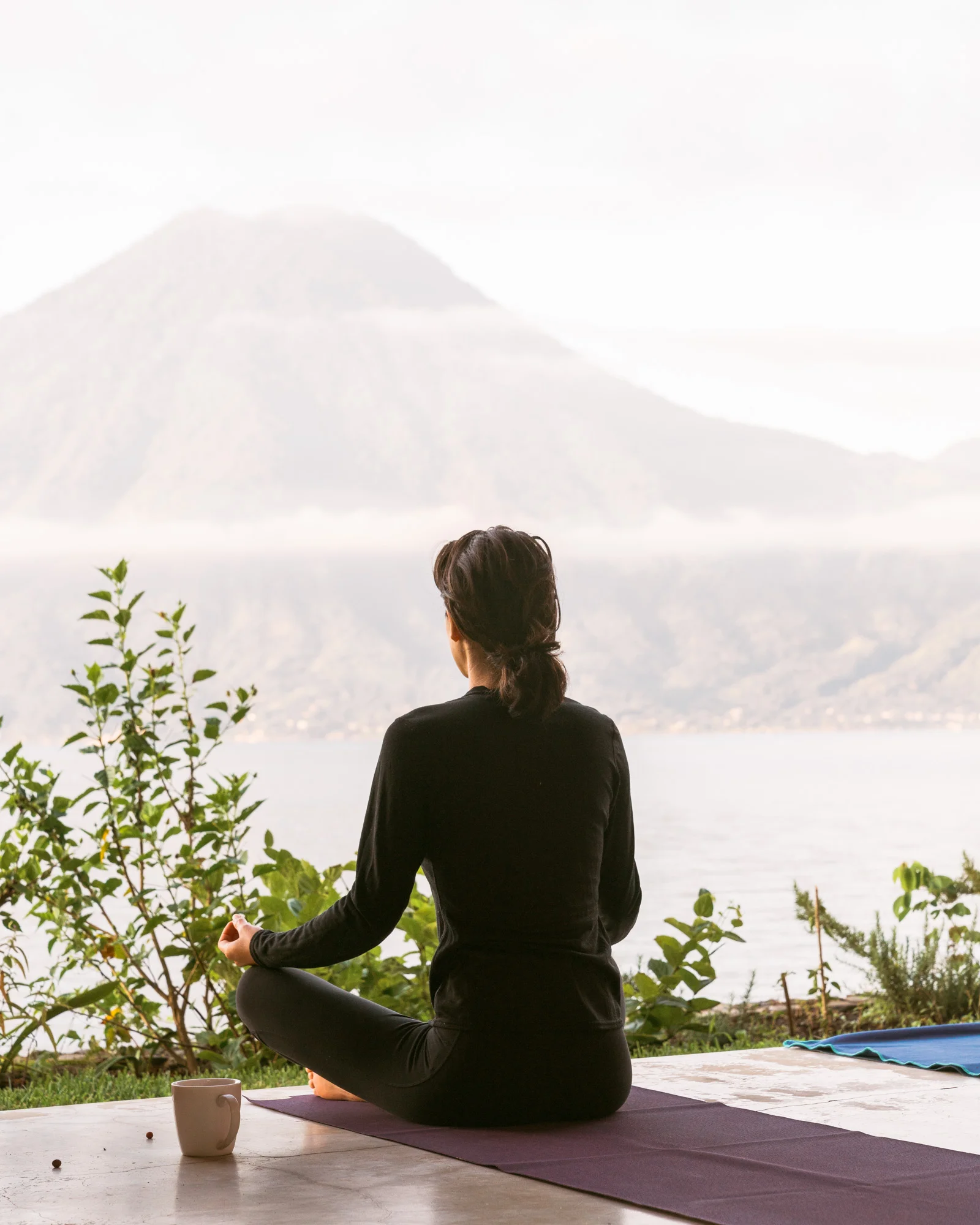 Woman meditating in front of the water at lake atitlan