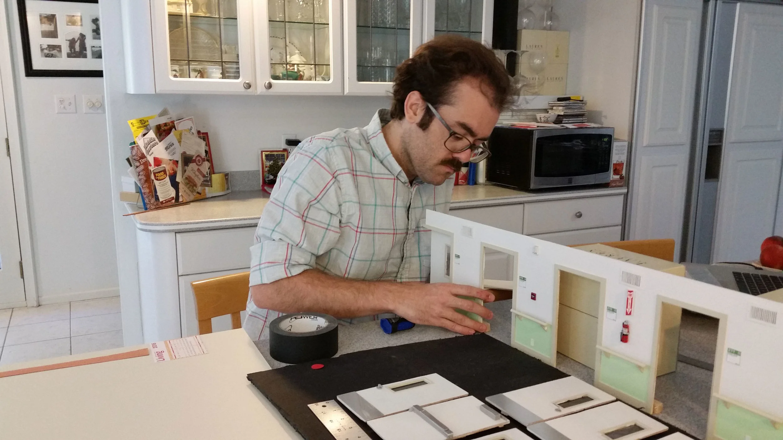 Director Sean David Christensen sizes up the dimensions of the miniature hospital set.