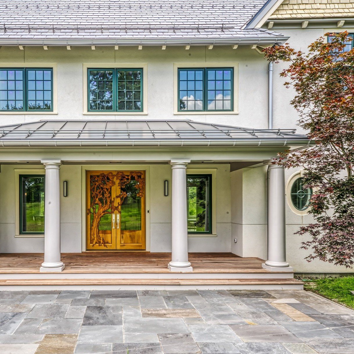 Discover the charm of our Early English Arts &amp; Crafts Revival project at the foot of the Shawangunks in Gardiner, NY! Check out this custom-made main entry wood door, featuring a hand-carved tree that beautifully echoes the adjacent Japanese mapl