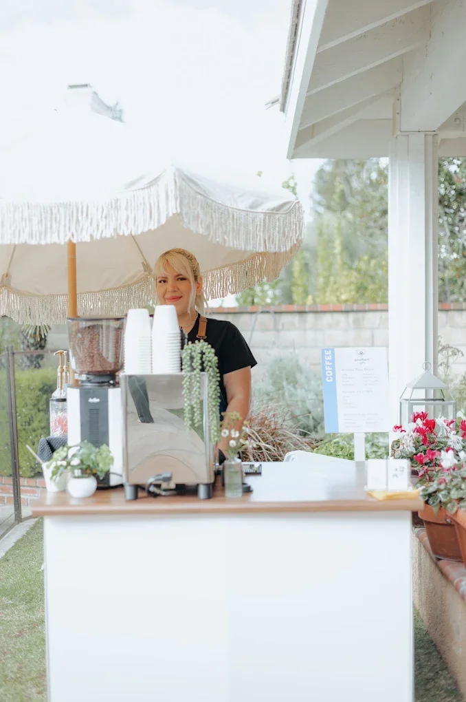 Houston barista service Goodhart barista smiling softly behind her coffee station at an event.