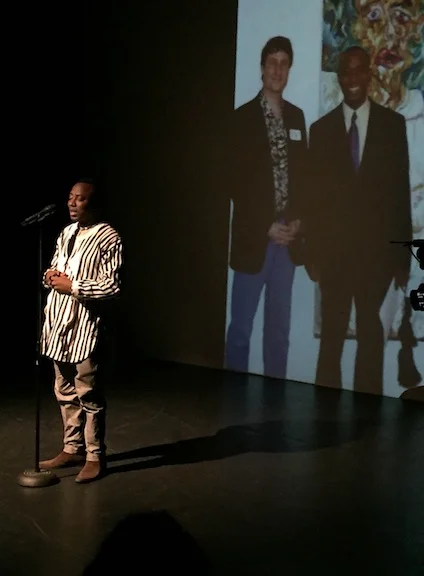 Omoyele Sowore at the inaugural International Human Rights Art Festival at Dixon Place, March 3, 2017. Behind him is a projected image of him and Festival Producer Tom Block, in front of a painting of Mr. Sowore by Mr. Block, in 2002 at the AFL-CIO Headquarters in Washington DC.