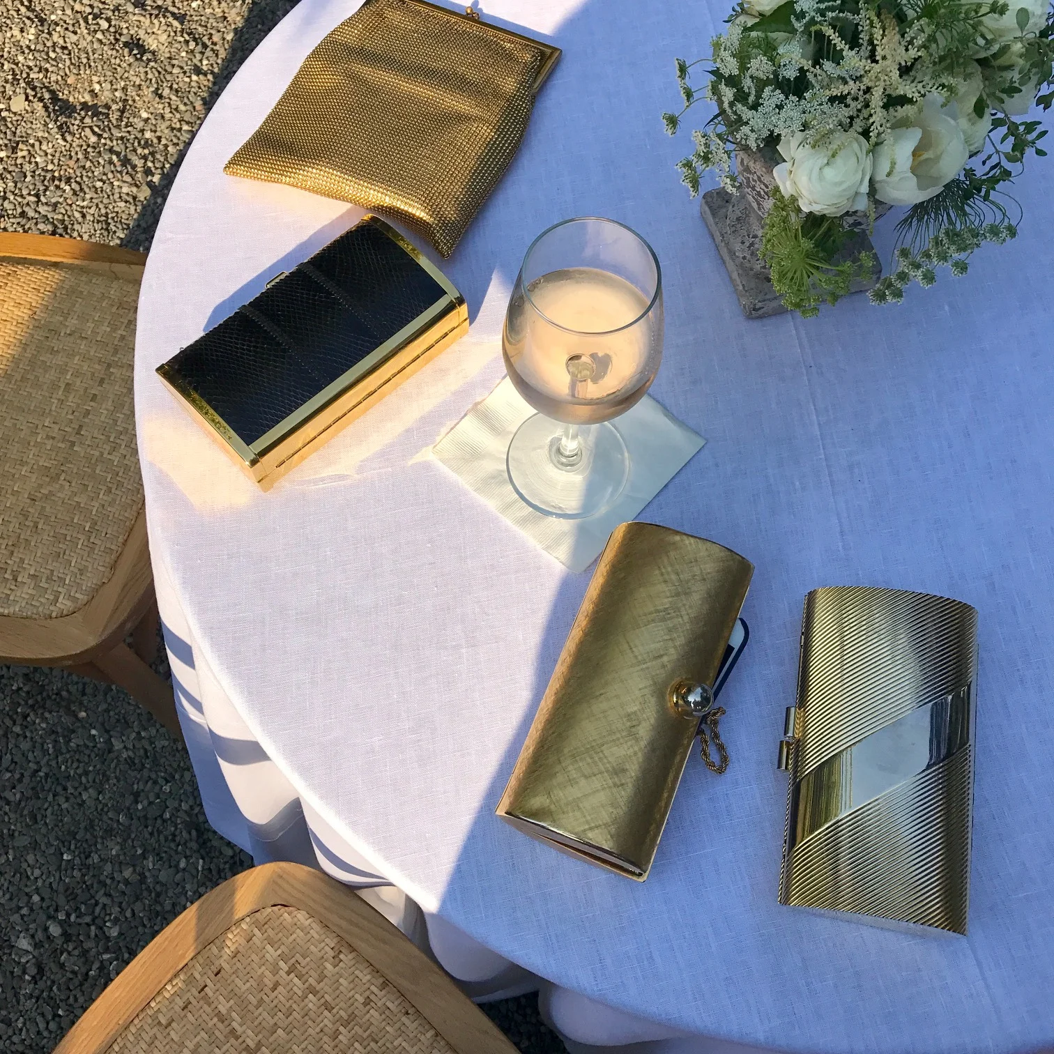 Gold clutches accompany a glass of rosé during cocktail hour in the garden. 