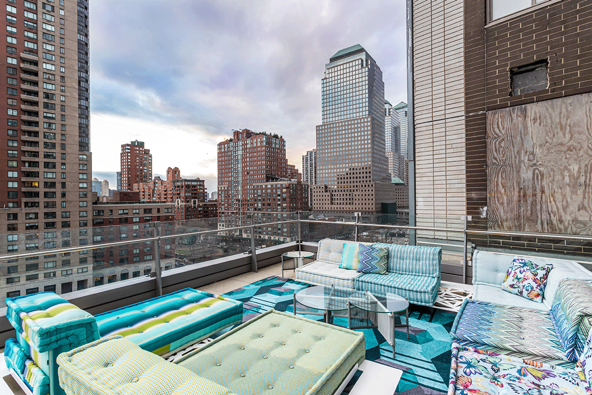 Large terrace balcony area with seating and a view of New York City