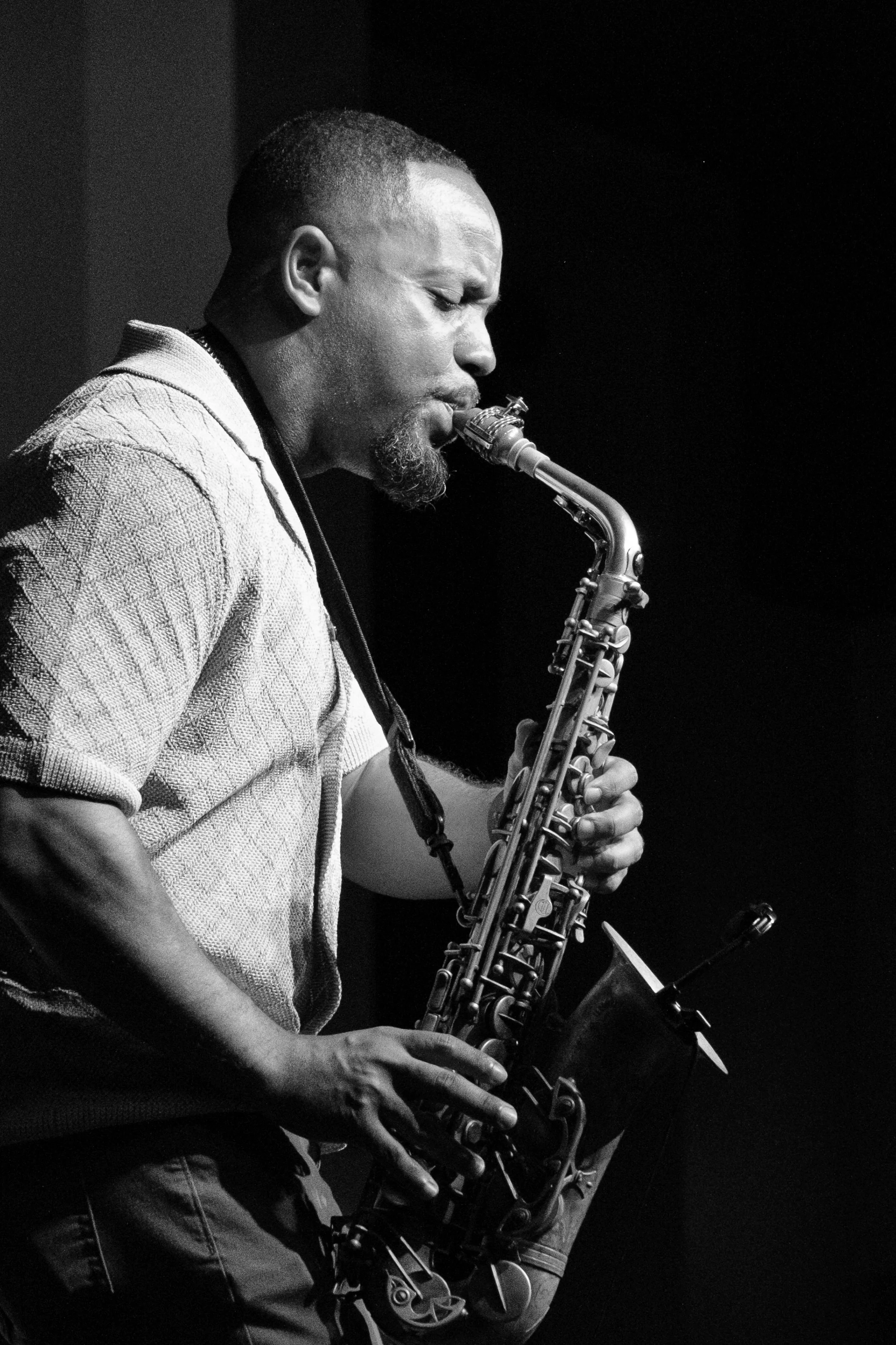 A close-up photograph of saxophonist, Riley Richard, playing at a concert.
