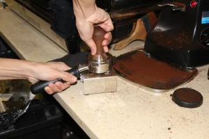 Coffee grounds are subsequently packed tightly, in a process known as “tamping,” into the portafilter to allow water to even distribute throughout the grounds during the brewing process.