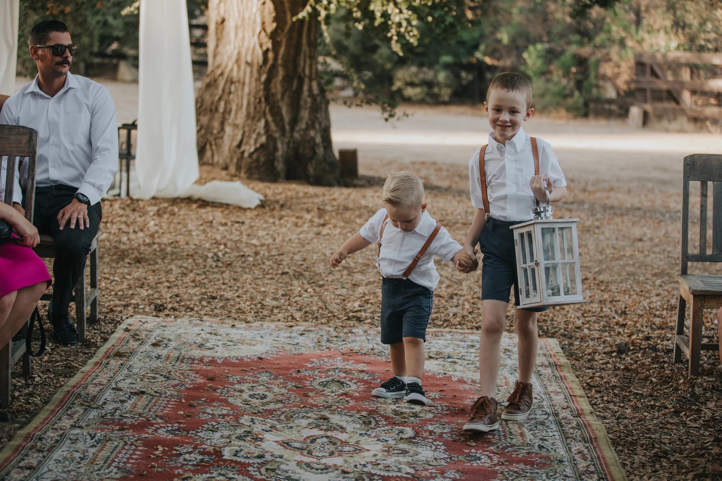 Ring bearers walking down a vintage carpet aisle at a wedding in the Temecula Valley.