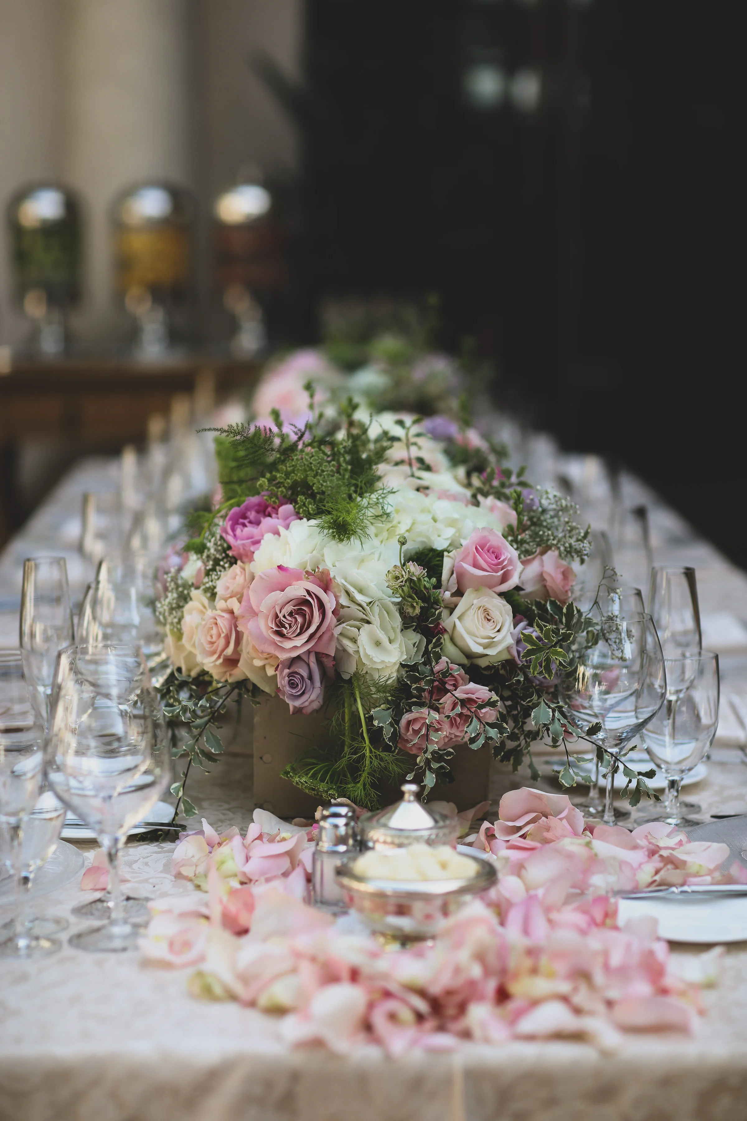 Wedding centerpiece on the bridal table with pink rose petals at the Resort at Pelican Hill in Orange County.