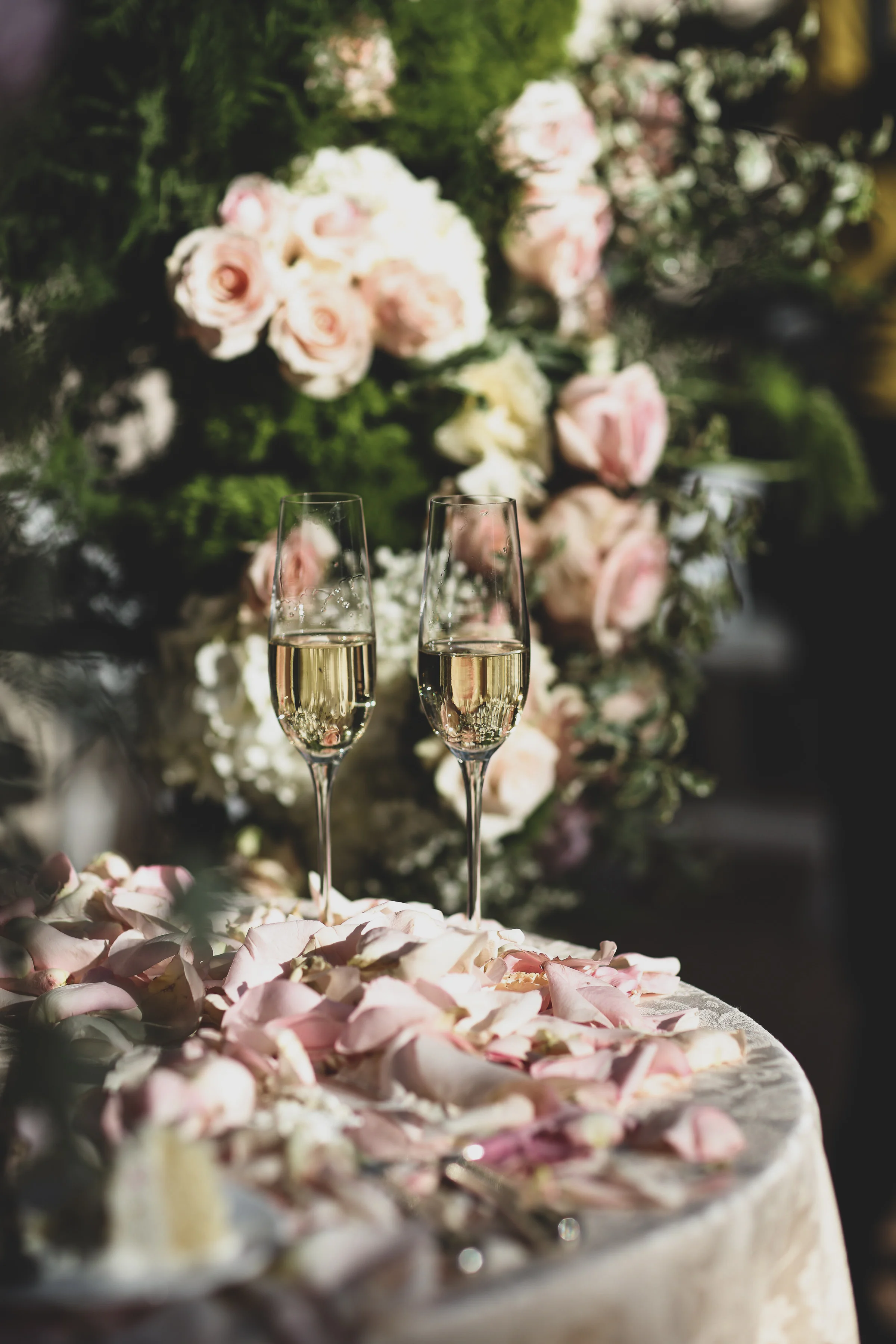 Champaign and rose petals on a wedding table at the Orange County wedding venue, The Resort at Pelican Hill.