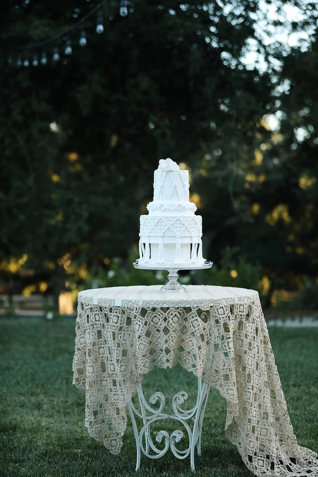 Macrame wedding cake by Susan Carberry on top of vintage lace table cloth and wrought iron table. All vintage rentals from Birdie in a Barn in the Temecula Valley.