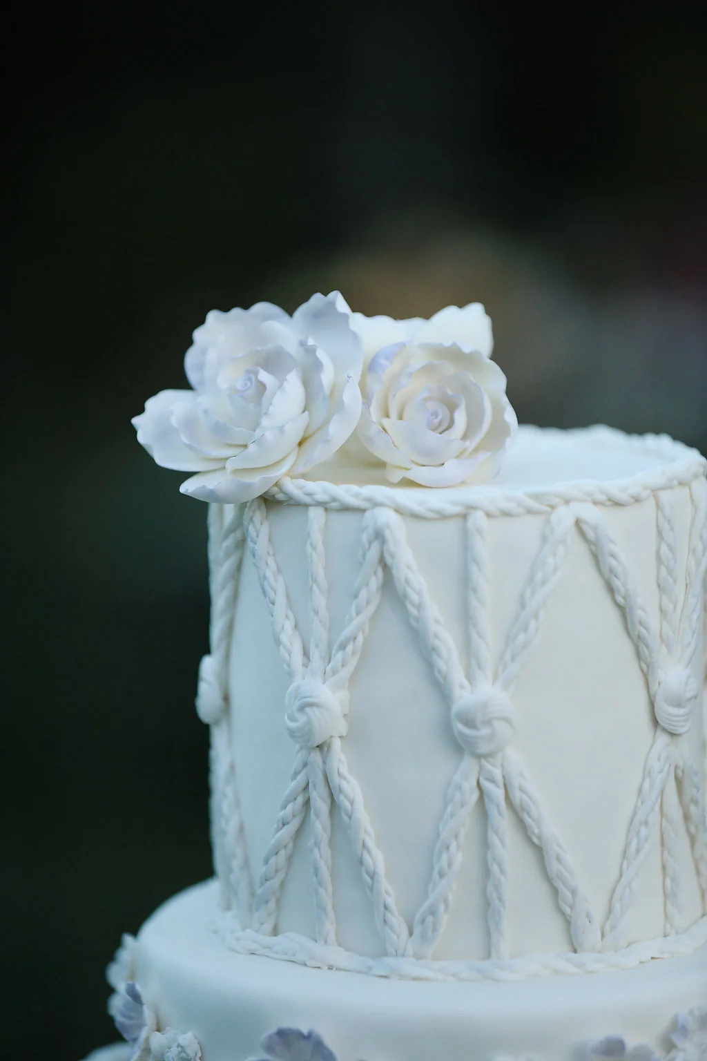 Close up details of the macrame wedding cake with gum paste flowers.