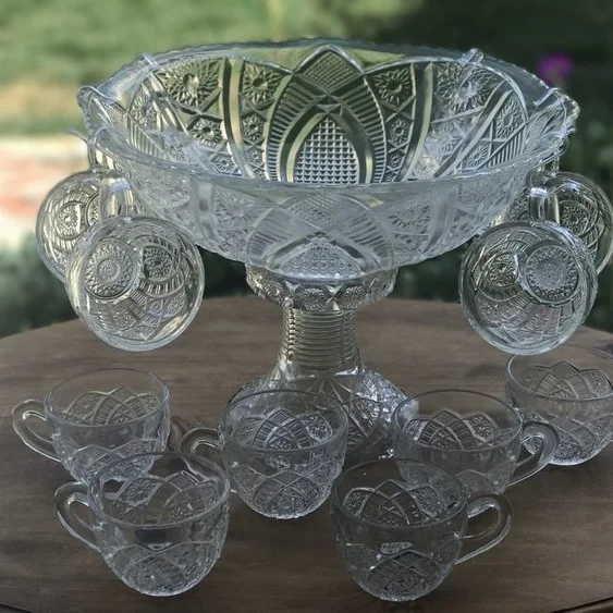 Small Punch Bowl Set Cut glass punch bowl with an intricate swirl pattern on decorative base. Comes with 10 matching cups. Measures 7.5 inches tall with the base included.