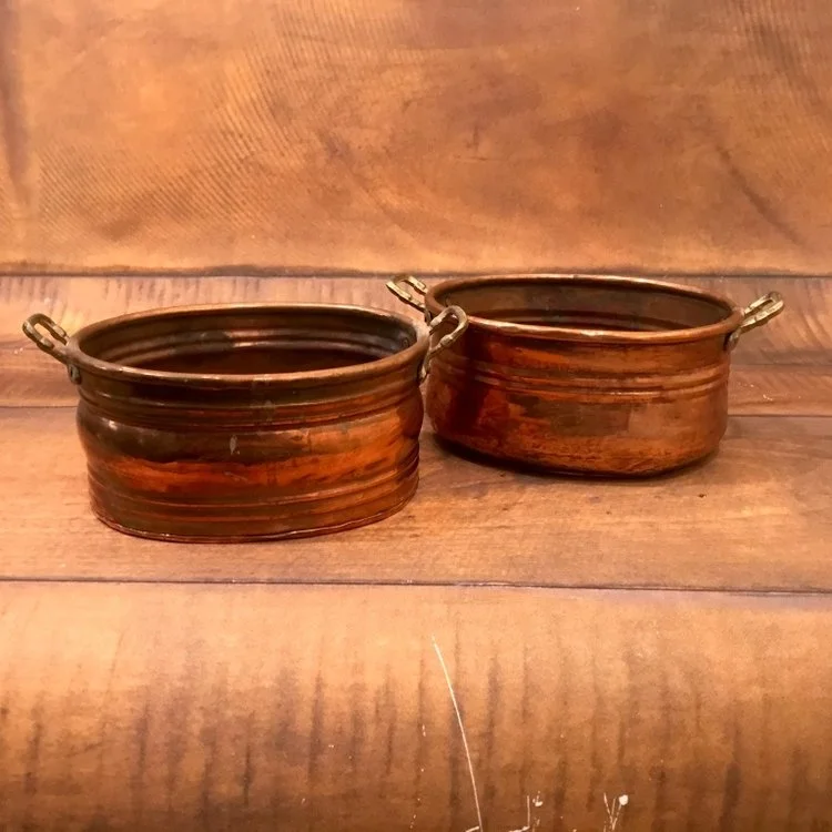 Little oval copper pots with handles.