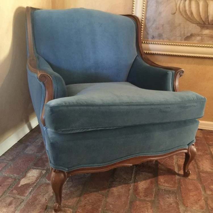 Ford Vintage, but newly upholstered, blue velvet chair framed with a walnut, scrolled, wooden edge. French Provincial style legs. Seat 22.5"x 30" Overall height 33".