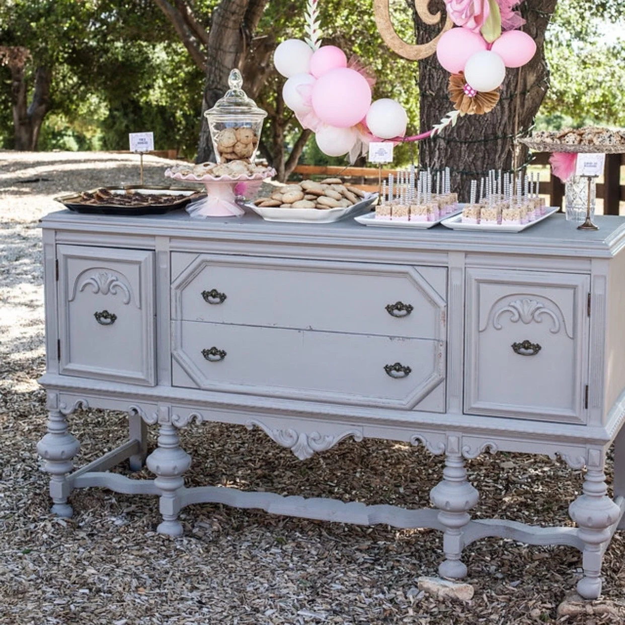 Hattie French Linen antique buffet with two doors and two drawers. Hot pink interior. Scalloped bottom with four ornate legs. 70" x 22" rectangle. 37.5" tall.