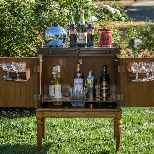 Tanner A true Mid-century Modern portable mini bar on wheels. Chrome lid that opens for mixing drinks. Two doors open for ice bucket, bottles, glasses 27" long x 17" wide. 33.5" high.