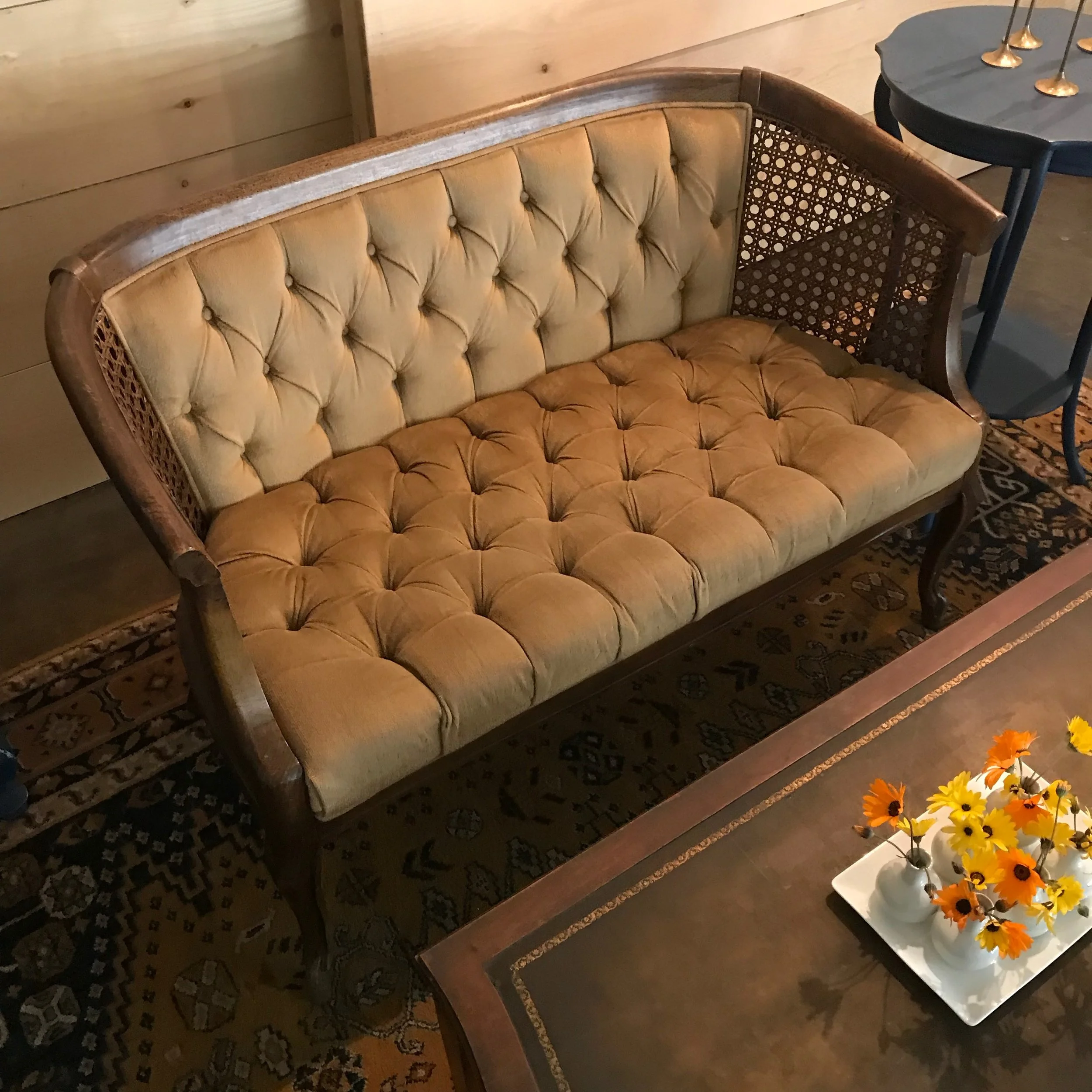 QuinnVintage gold velvet loveseat with tufting on the seat and the back.  Caning on both sides of the seat.