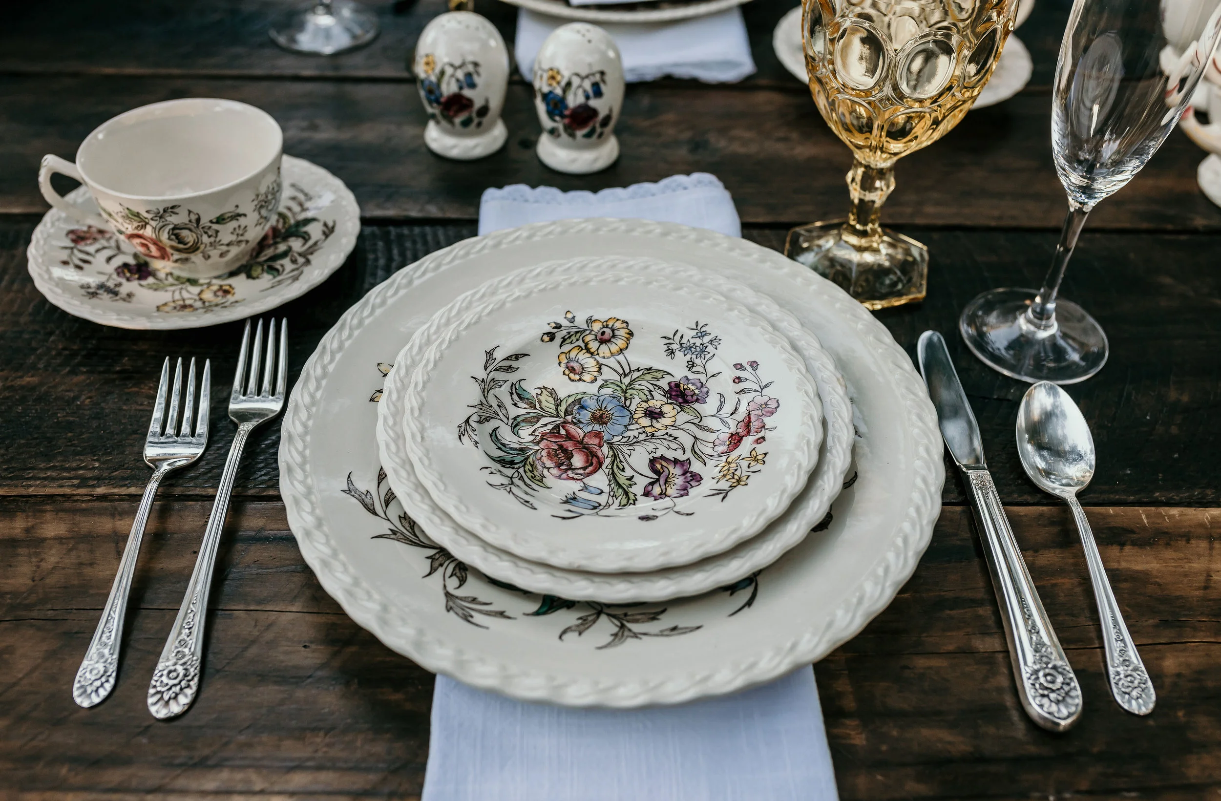 Vintage Johnson Brothers china set on a farm table with vintage goblets and silverware. This was used in the Alice in Wonderland styled shoot at Chateau Adare in Murrieta.