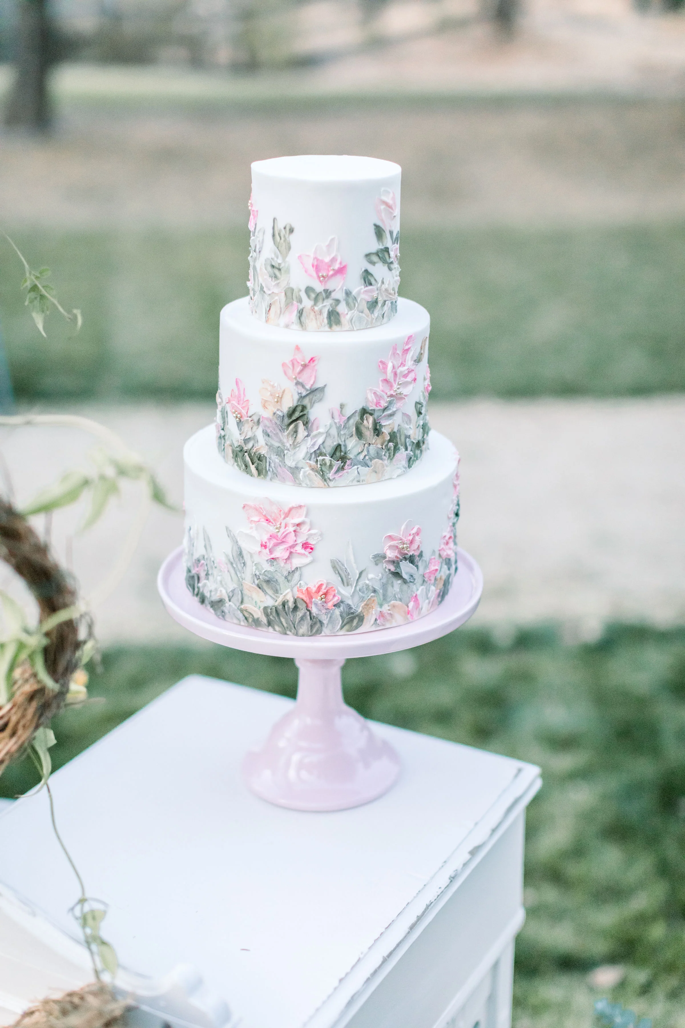 Pink Wedding cake on a pink pedestal cake plate.