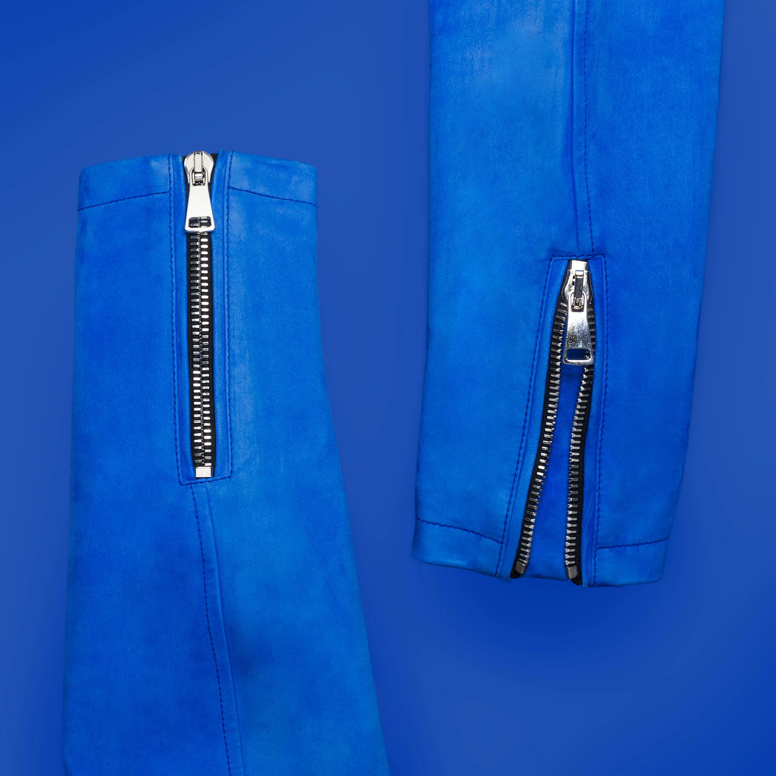 Close-up of two blue fabric items with metal zippers against a blue background.
