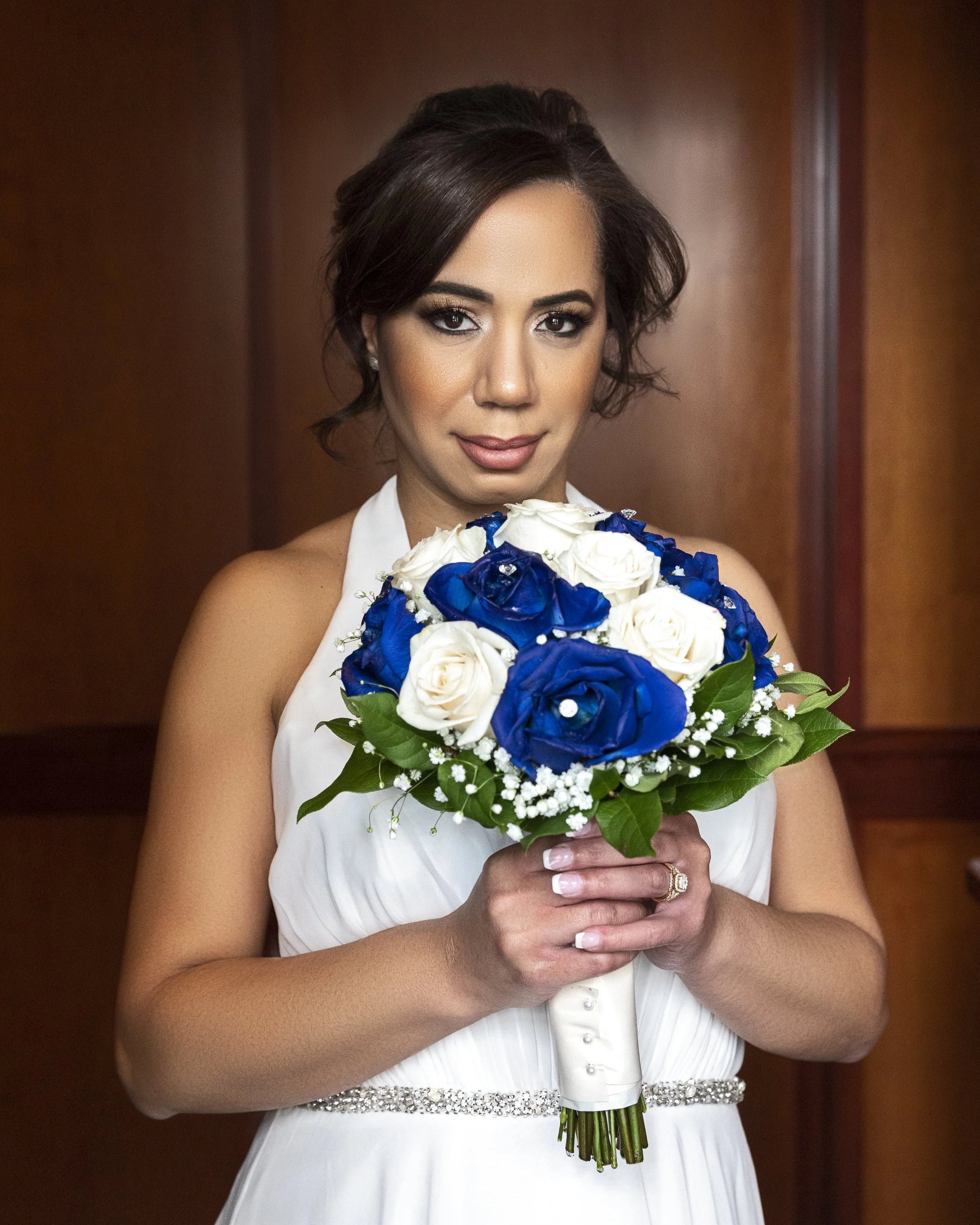 Bride holding bouquet of white and blue roses