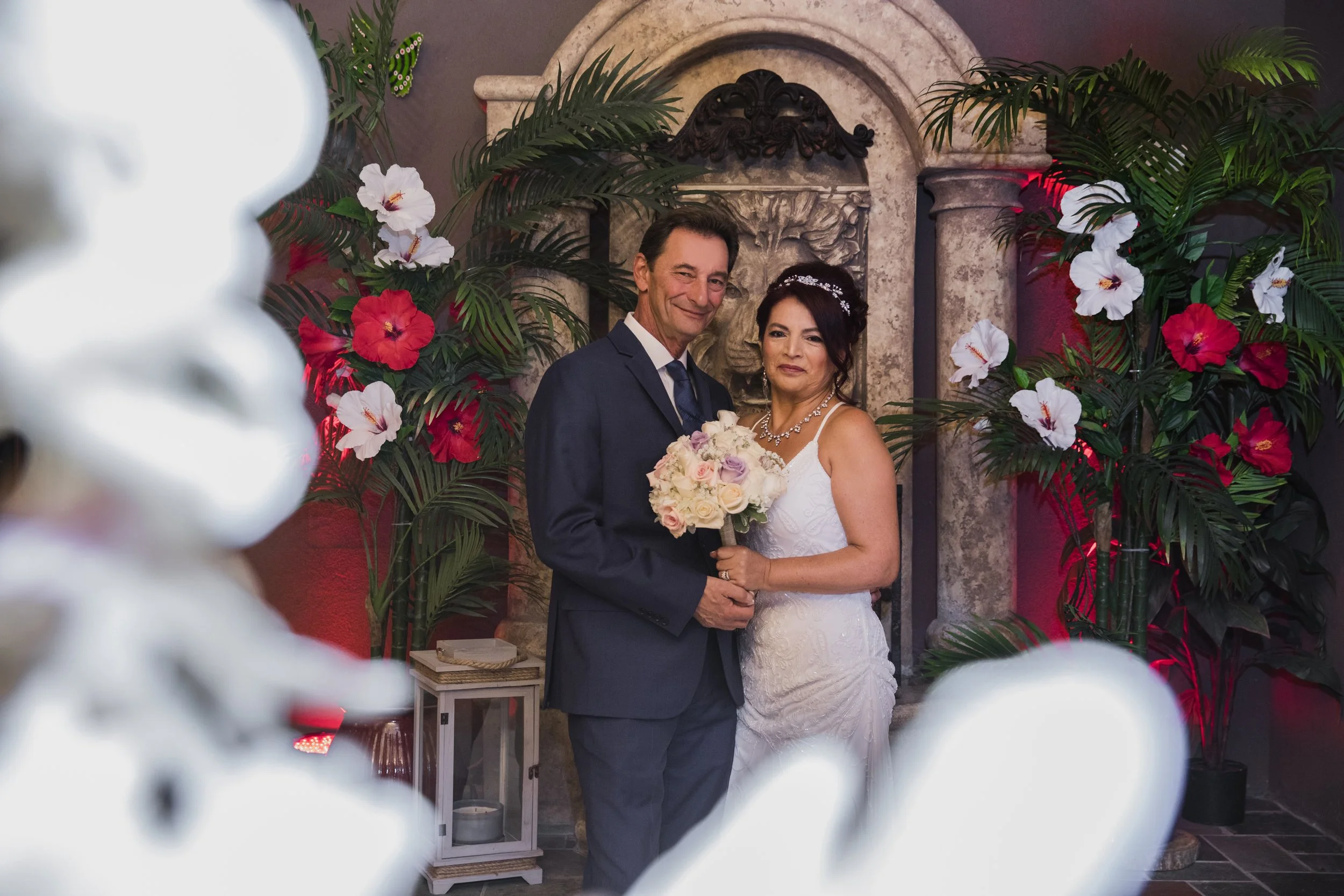 Bride and groom posing indoors with floral decorations