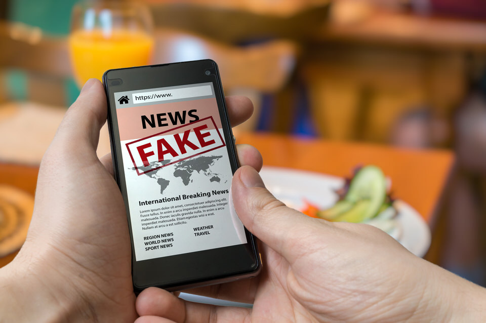 Man-is-holding-smartphone-and-reading-fake-news-on-internet.-Propaganda,-disinformation-and-hoax-concept.-884190960_2127x1413.jpeg