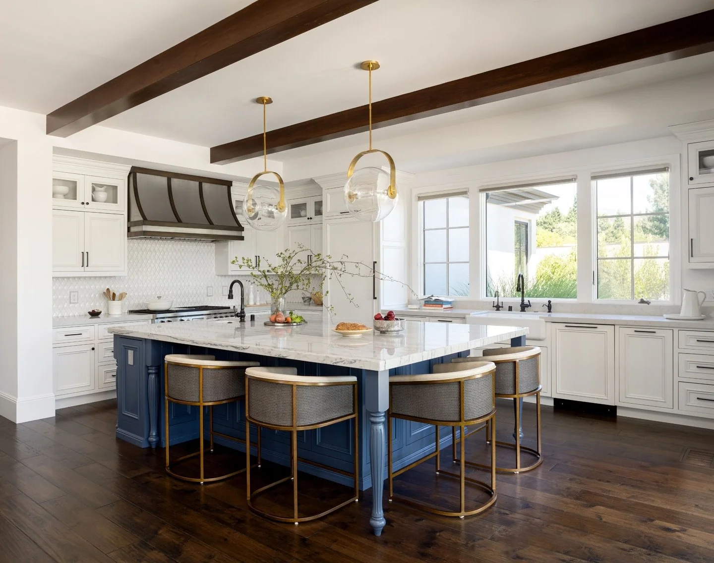 A kitchen designed to feel both timeless and lived-in.

This space balances classic detailing with modern function &mdash; layered cabinetry, warm wood beams, sculptural lighting, and a central island designed for gathering. Every decision was made t