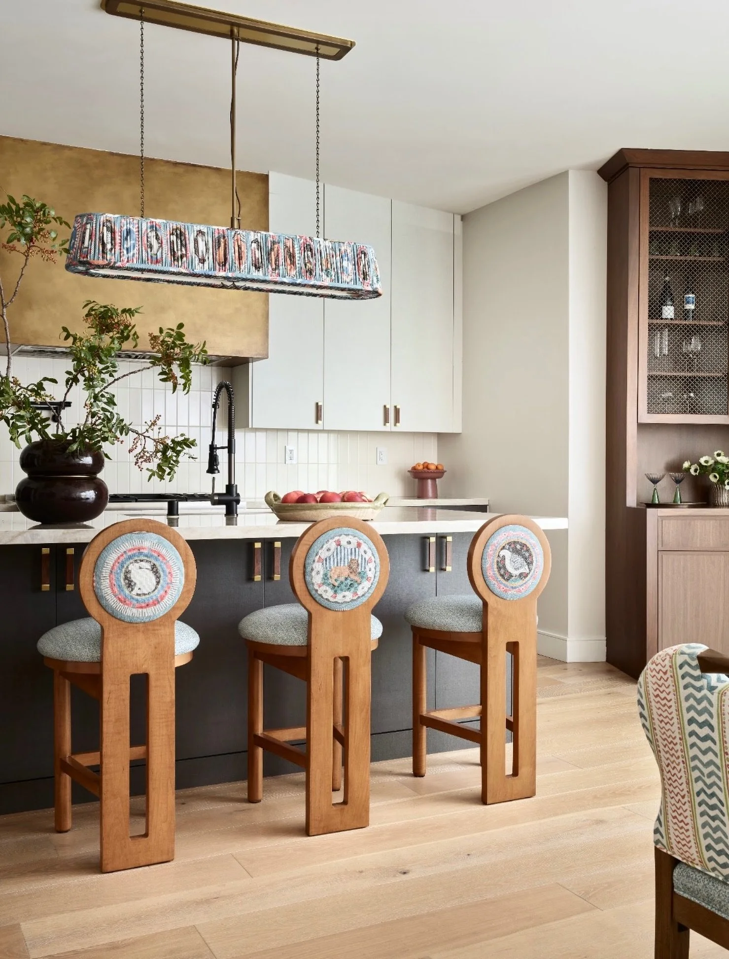Pattern, texture, and a little bit of the unexpected. 🥳

A kitchen doesn&rsquo;t have to be all cabinetry and stone. We brought personality into this one with sculptural counter stools, patterned upholstery, and the most perfect light fixture from @