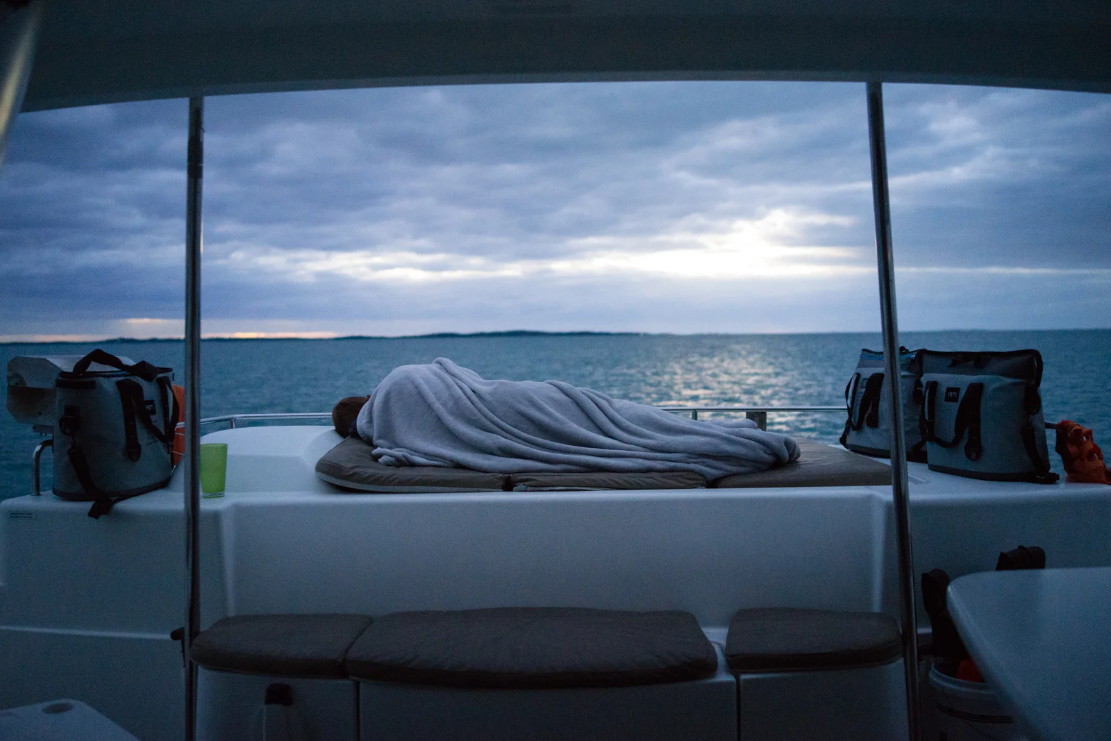 I rose early this morning to check out our skies and seas. Everyone was still asleep, including Cheffy Chris who I caught bundled up in a rare moment of repose. 