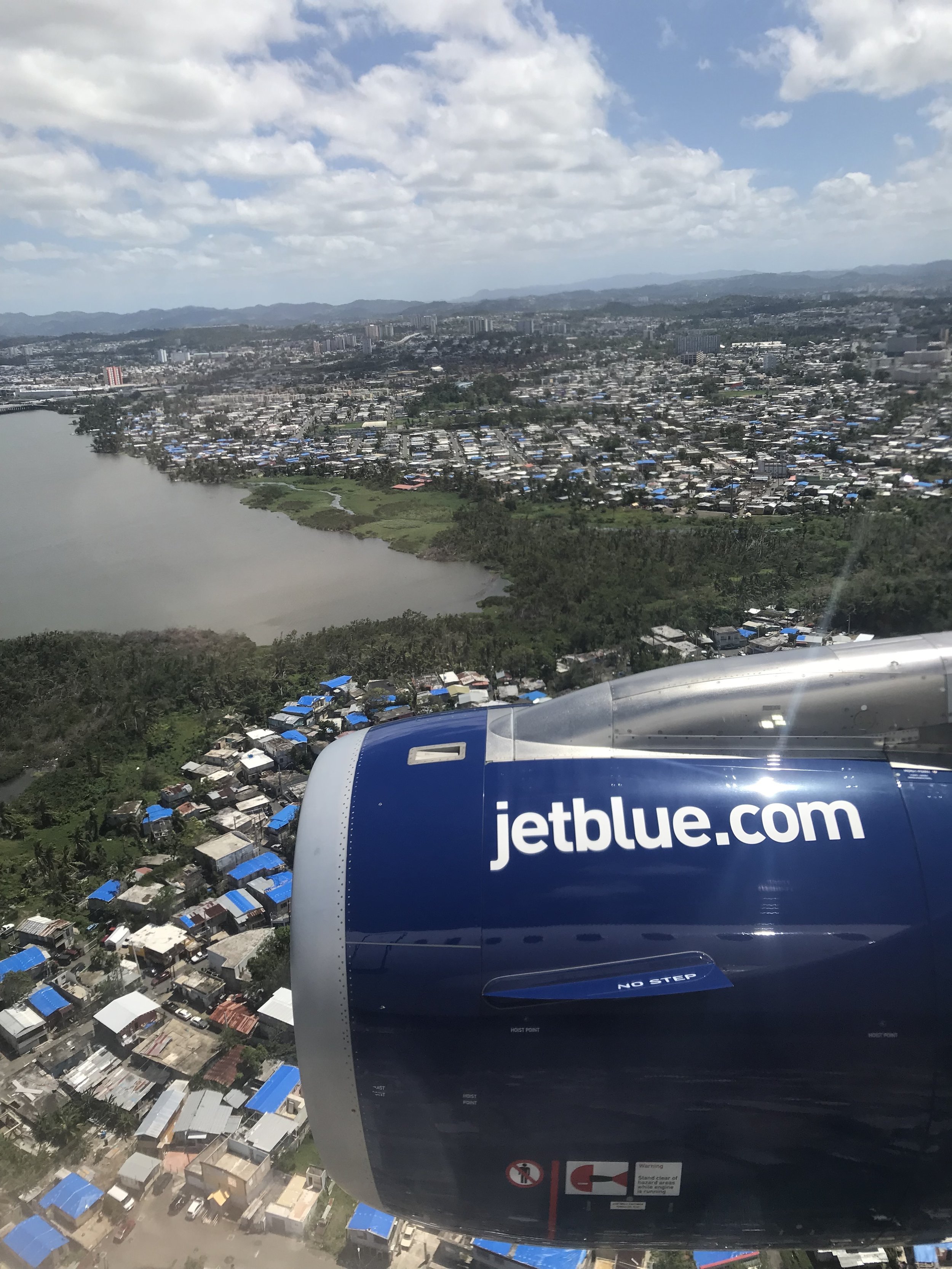 Blue tarps on San Juan roof tops, scars of Hurricane Maria.