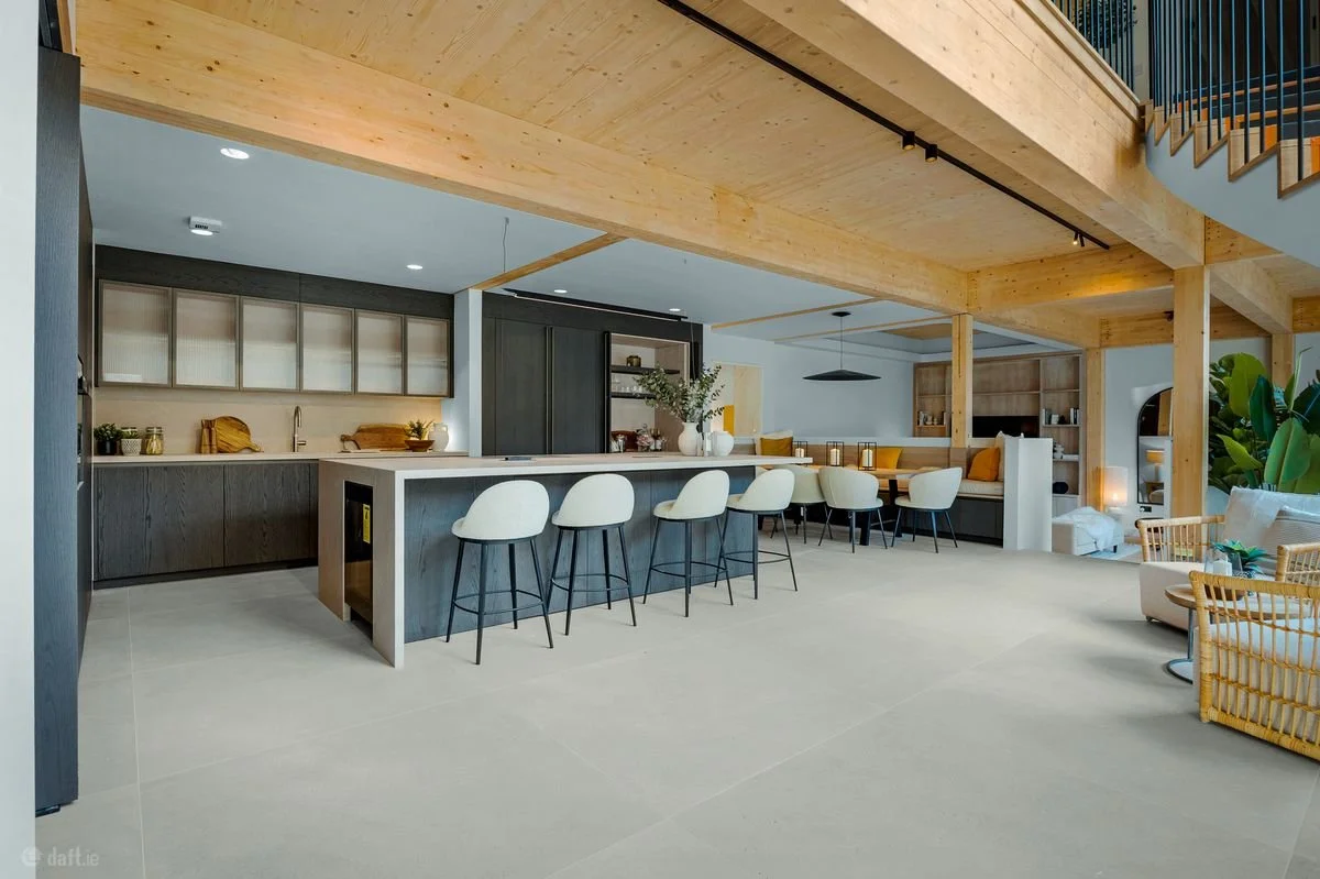 O House kitchen and dining area with warm timber beams, neutral seating and home staging by MKOD