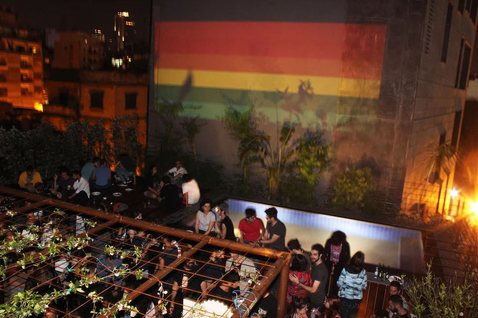 A rooftop party with a rainbow flag projected on the neighboring building during Beirut Pride 2017. (HADI DAMIEN)
