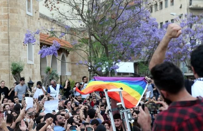 Activists carry the LGBT pride flag during a protest in Beirut, Monday, May 7, 2018. (The Daily Star/Hasan Shaaban)