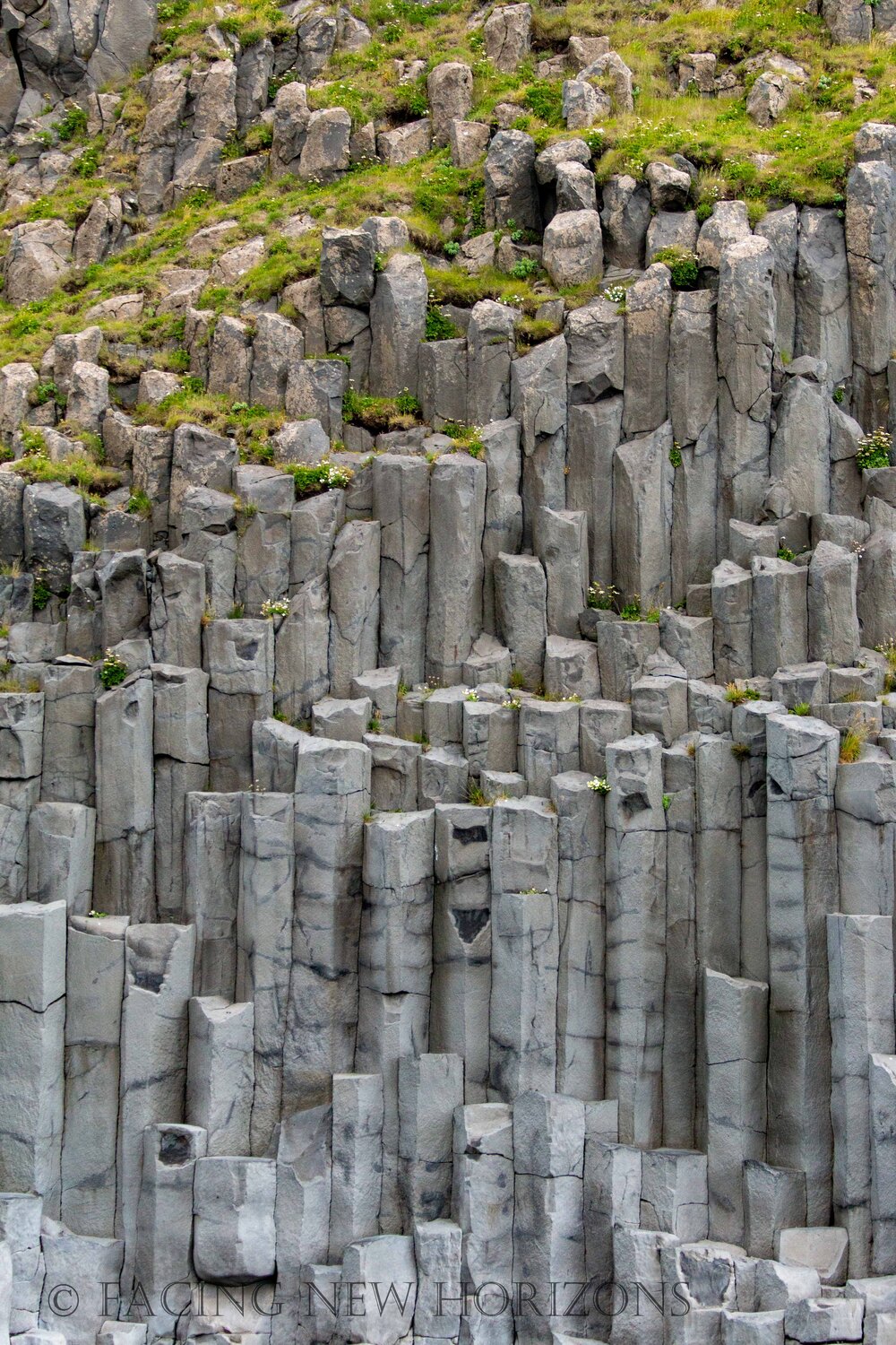  Basalt columns protruding from the beach in their natural geometric shapes 