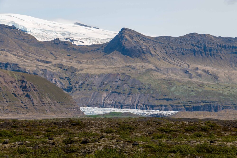  The Vatnajökull Glacier covering the mountains, icy pools of water below 