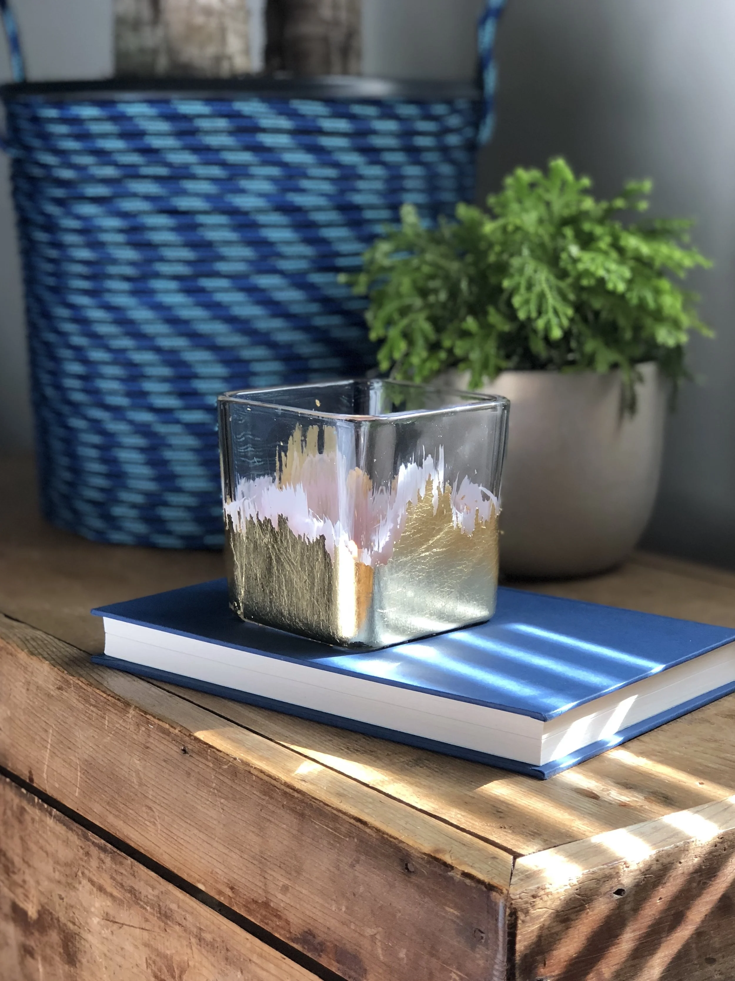 Easy Spring DIY's ROPE BASKET PLANTER MATERIALS: Colorful Poly Rope, Plastic Nursery Pot, Hot Glue GOLD LEAF CANDLE HOLDER MATERIALS: Glass vessel, Milk glass or acrylic paint, Gold leaf, Gold leaf adhesive