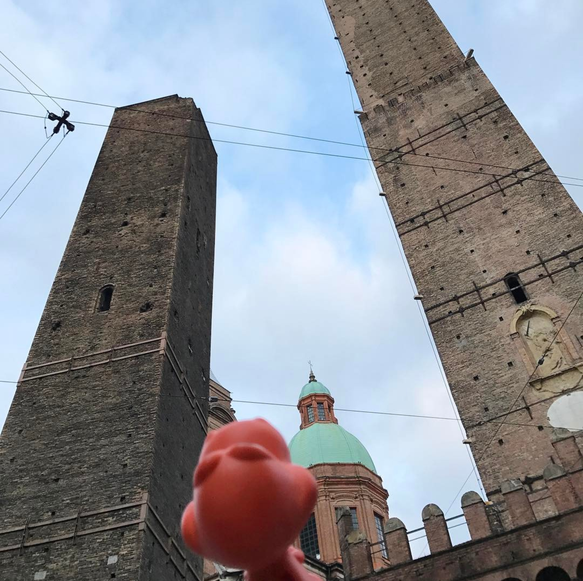 The little dinosaurs are wandering around the Bologna City Centre! Can you tell them where they are visiting? Rexi, "Wow! The tower is too tall that I cannot see the top of it!" 