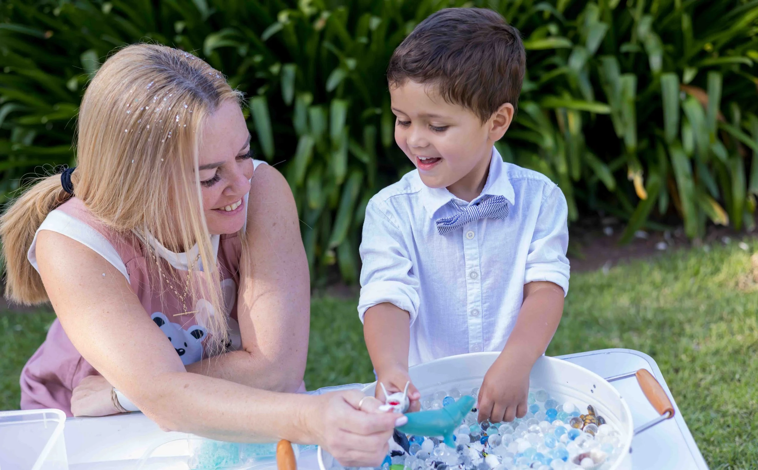 Professional nanny playing with young child outdoors at a wedding event by Timmy & Tammy Creative Childcare
