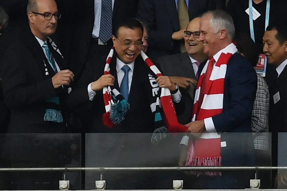 Chinese Premier Li Keqiang wears a Swans scarf at the AFL with Prime Minister Malcolm Turnbull. AAP/Dean Lewins