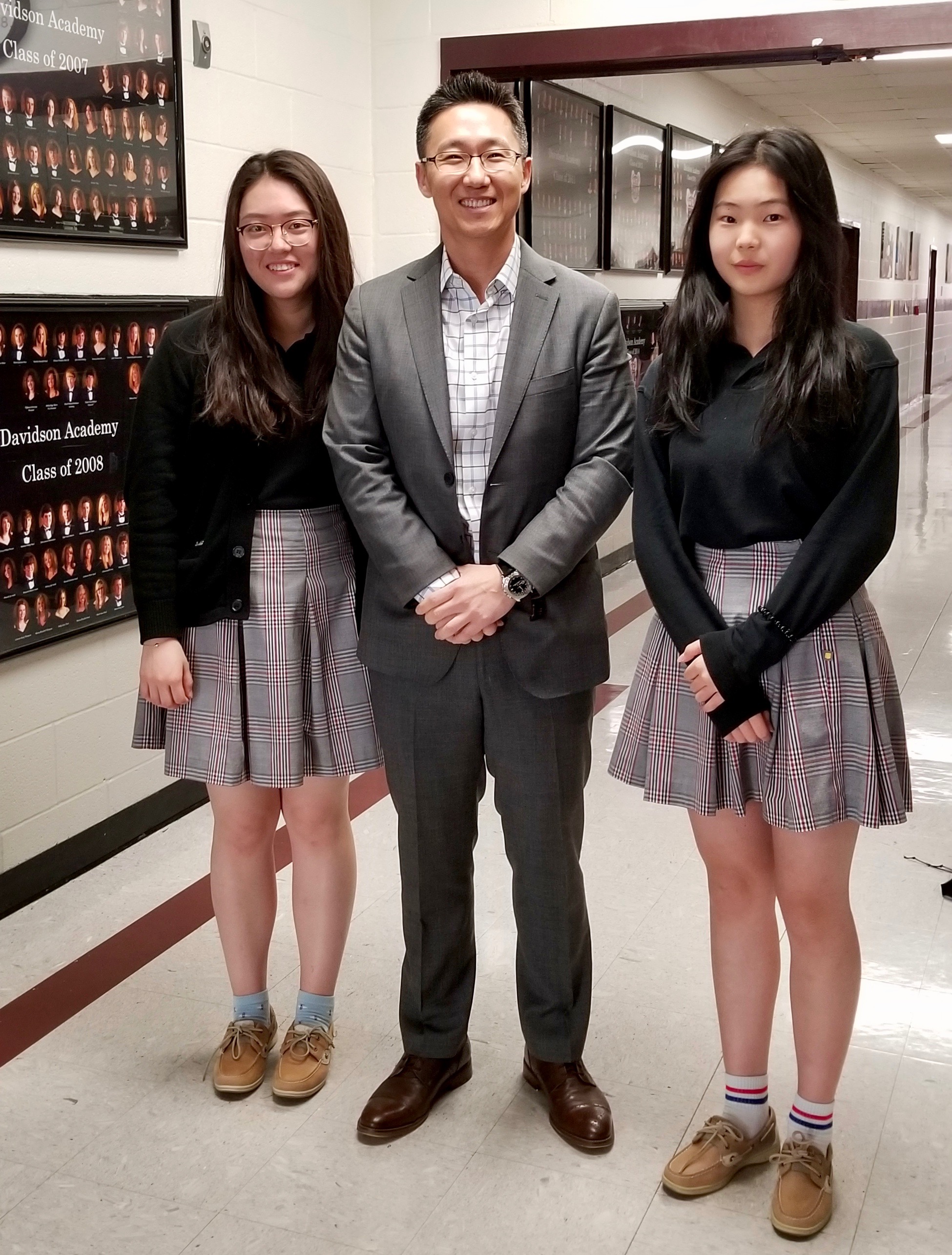Yuhan and Cassiel with Mr Peter about to review a resesrch paper before submission.