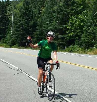 Carrie smiling as she bikes in the Lake Placid Iron Man, July 2016.