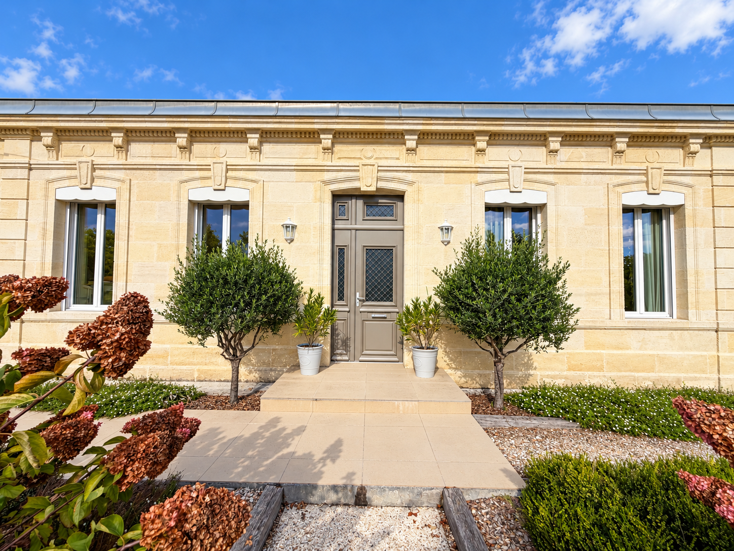 Façade néoclassique en pierre baignée de soleil.png