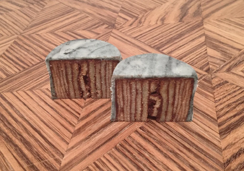 Cut open, revealing the striped inside. Chocolate ganache and roll cake.