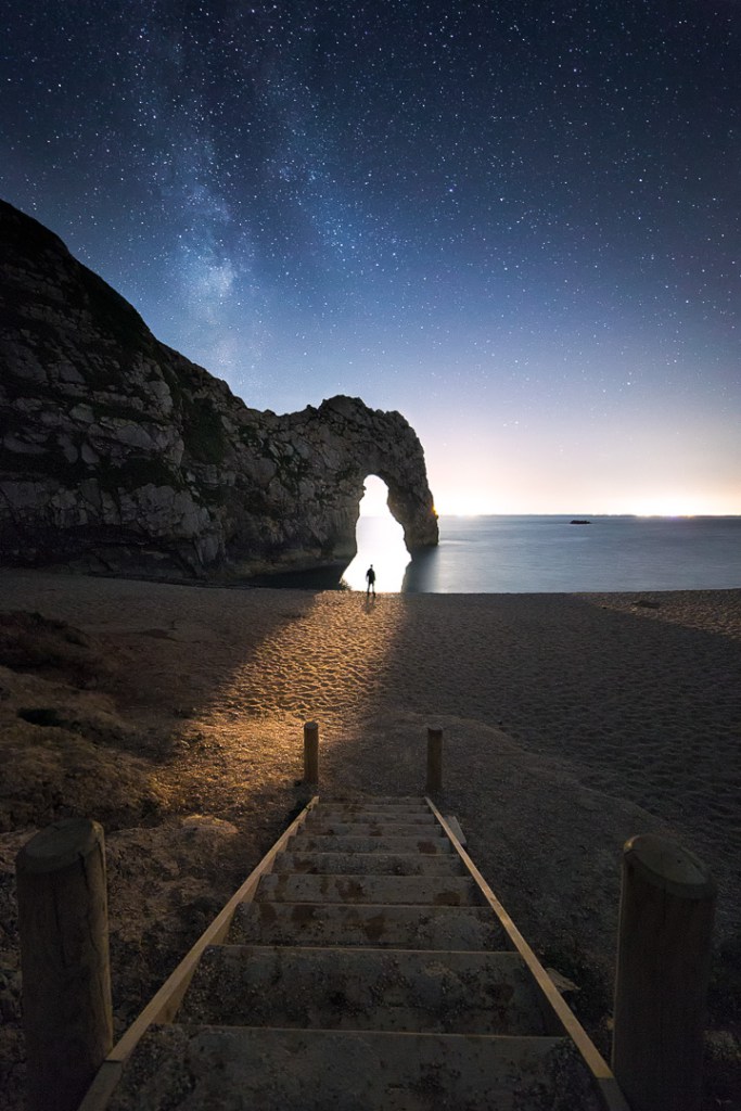 Moonlight spilling through Durdle Door as the Milky Way takes over the night sky