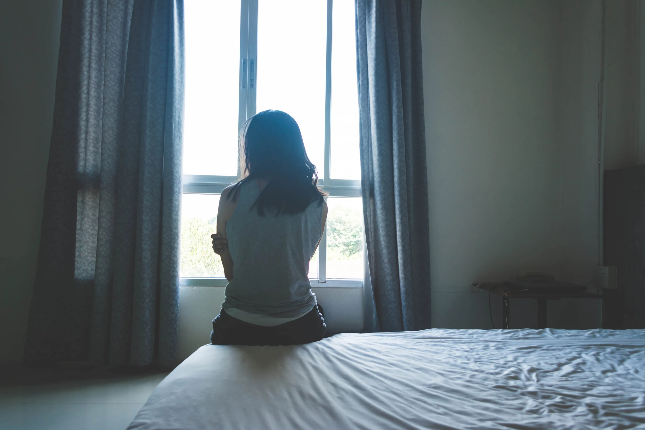 dreamstime_l_101816212 woman sitting on bed.jpg