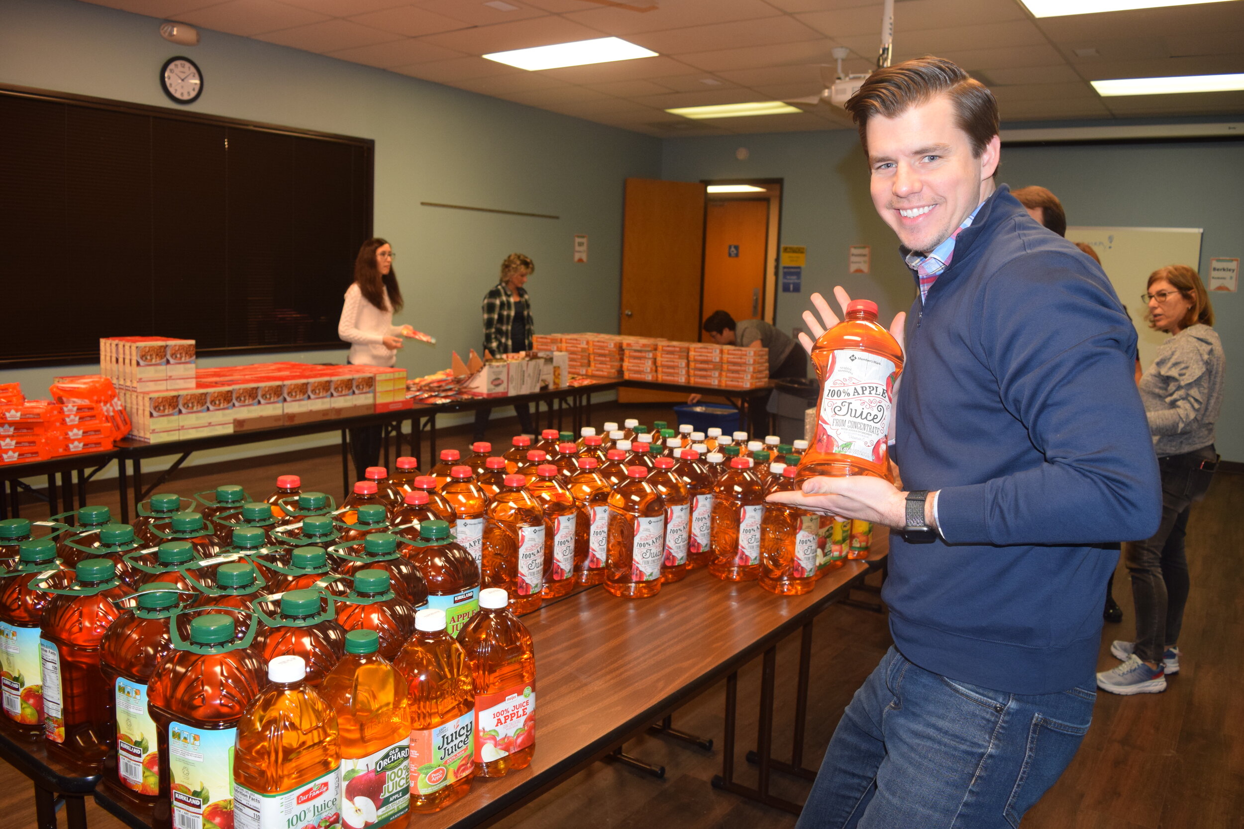 Volunteers placed apple juice in Thanksgiving baskets for families to enjoy.