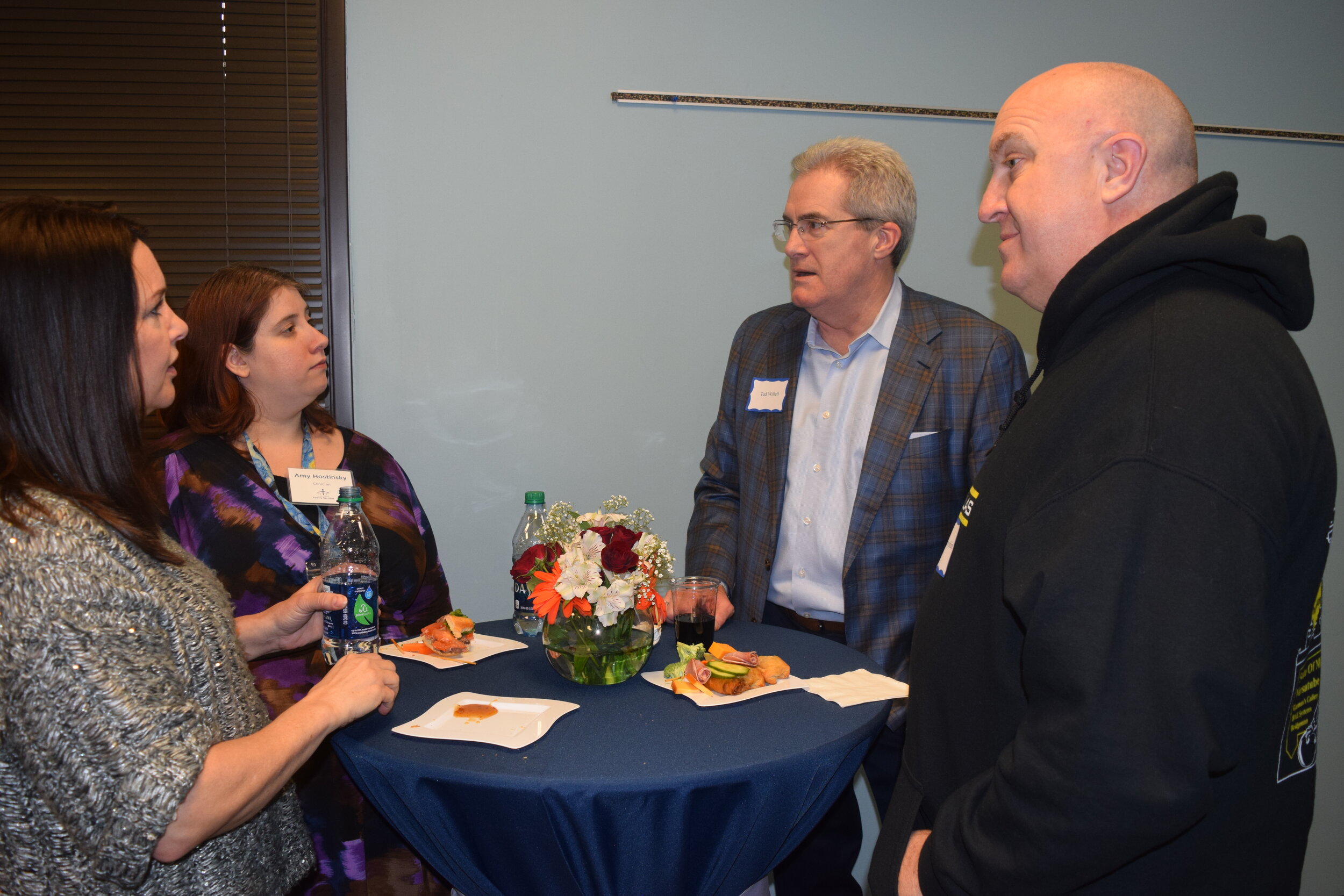 Board member Ted Willett (center) talks with guests.