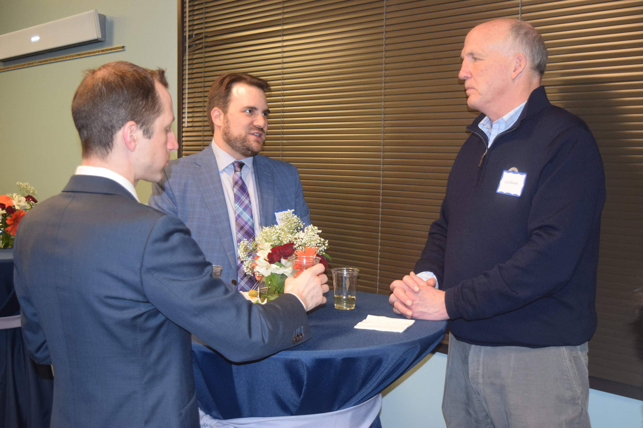 Board member Brian Newman (center) talks to guests at the event.